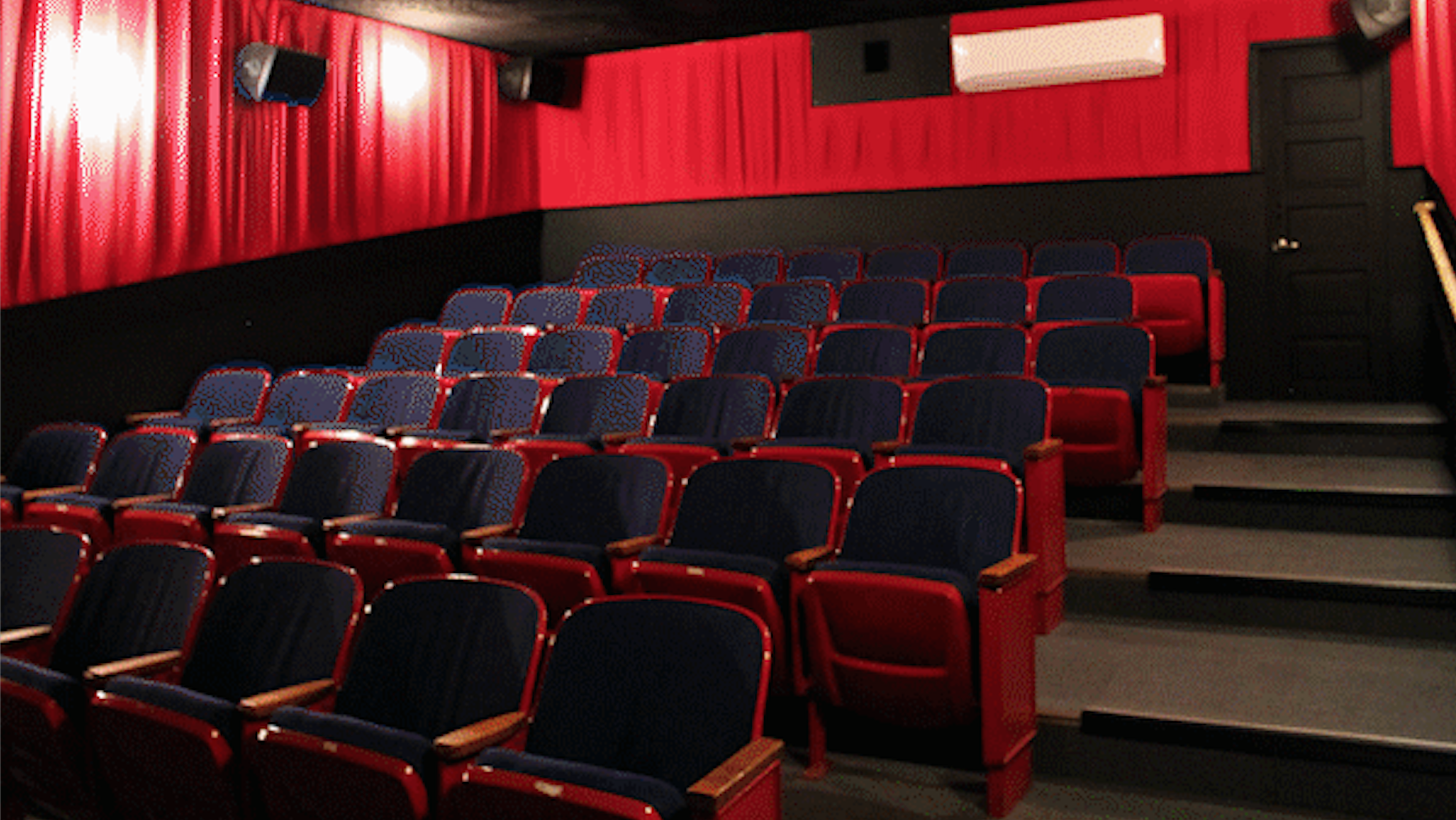 A picture showing the lovely red velvety looking seats in The Beacon theater's small cozy screening room.